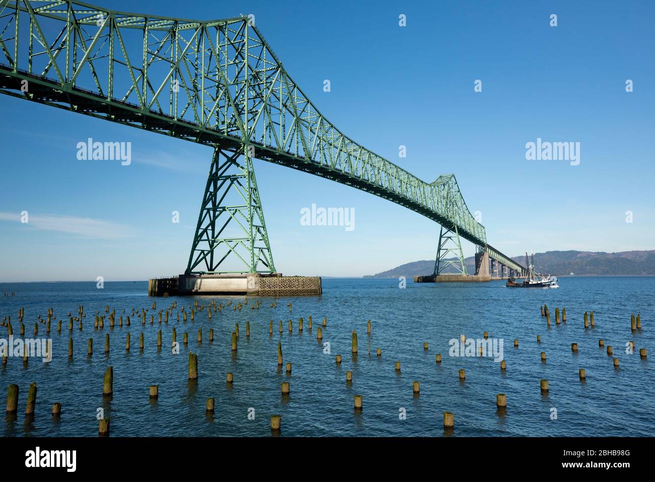 View of piles on sea, Astoria Bridge behind, Oregon, USA Stock Photo