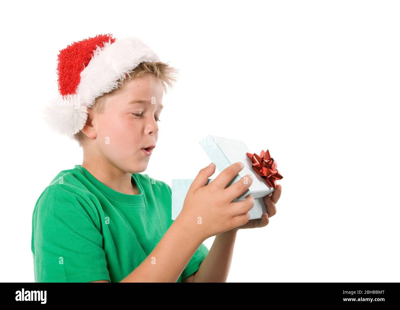 A boy opening a Christmas gift, looking inside box. Stock Photo