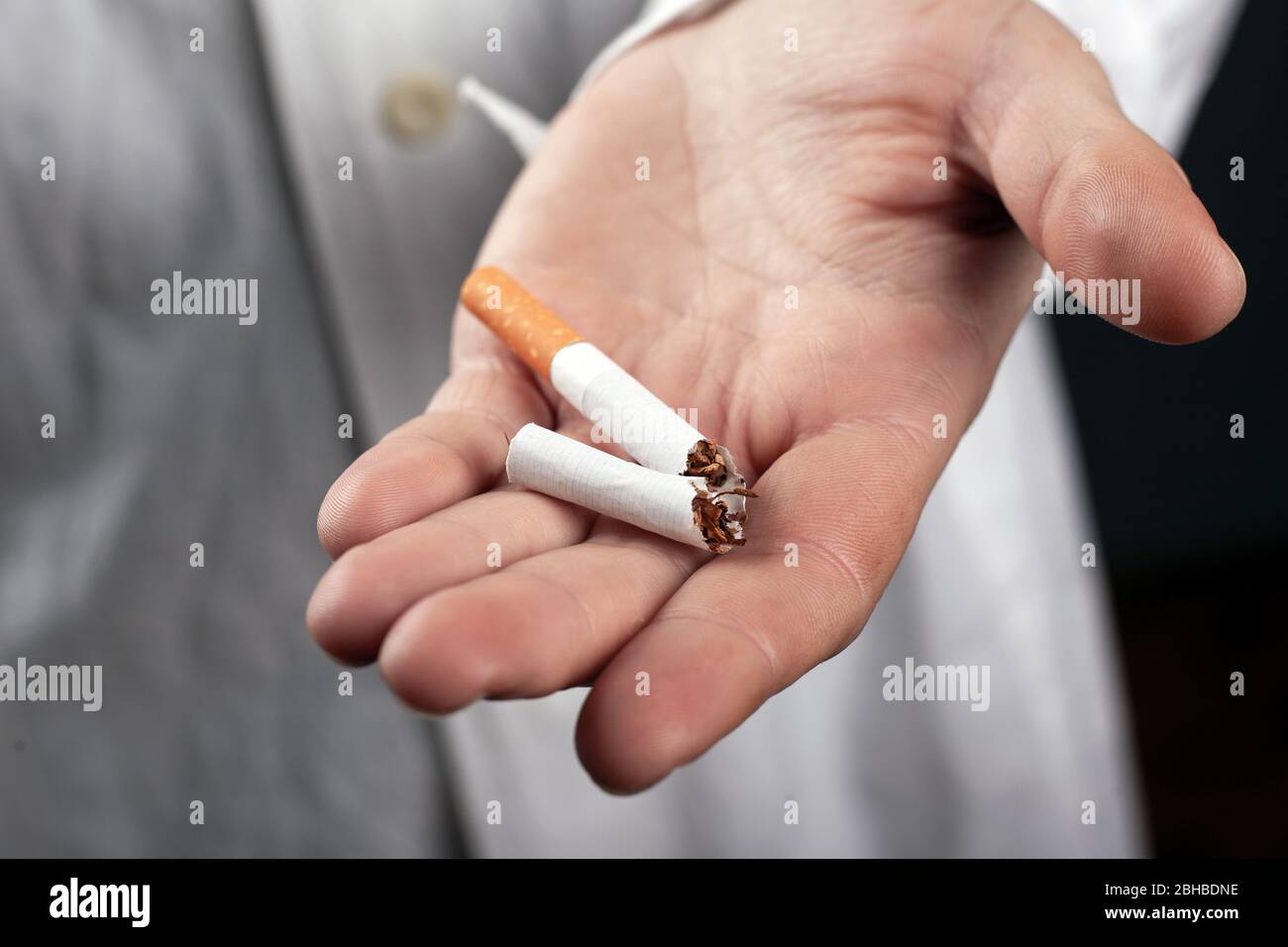 broken cigarette in the hand of a doctor closeup. health hazards from