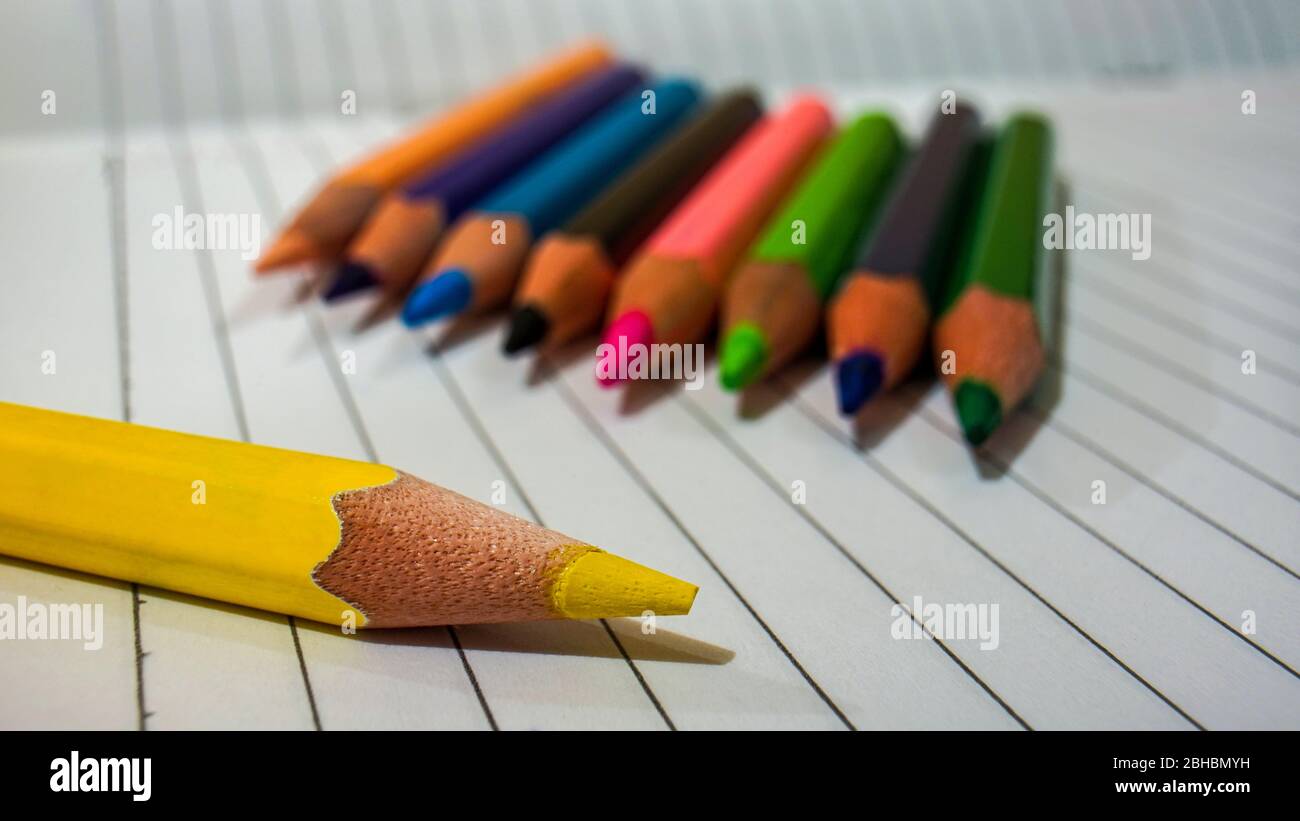Close up of some colored pencils placed on top of the notebook Stock Photo