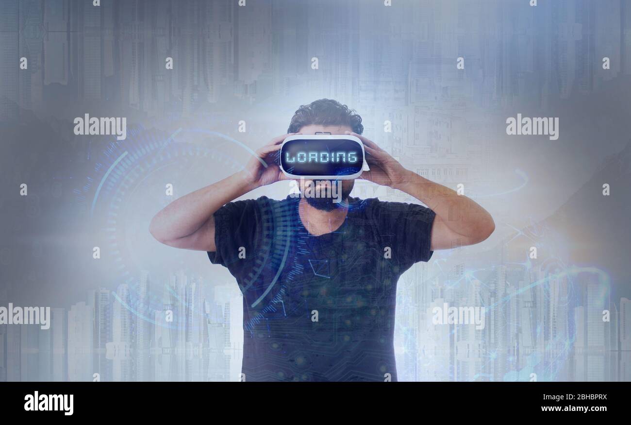 Young Guy in black t shirt wearing VR Virtual Reality glasses - Word Loading Stock Photo