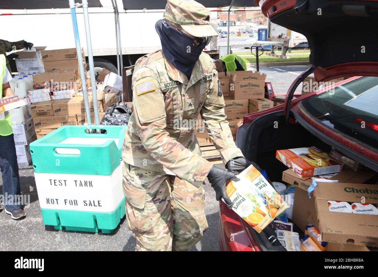 Alton, United States. 24th Apr, 2020. A Illinois National Guardsman, loads orange juice into the trunk of a car in the loading area in Alton, Illinois on Friday, April 24, 2020. Over 1700 cars lined up to receive food, distributed by the Urban League of Greater St. Louis. Photo by Bill Greenblatt/UPI Credit: UPI/Alamy Live News Stock Photo