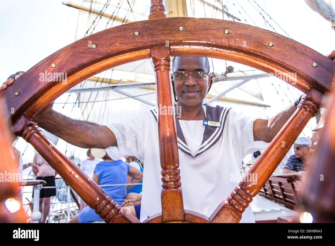Caribbean, Dominica. Star Clipper sailing ship. Sailor steering ship