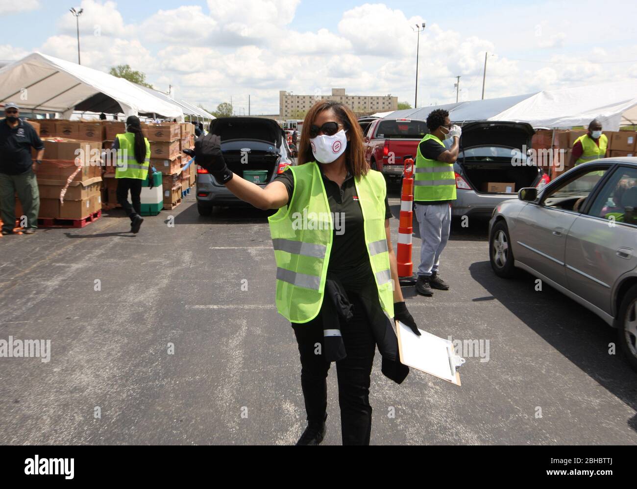 Alton, United States. 24th Apr, 2020. A volunteer guides a car into the loading area for free food in Alton, Illinois on Friday, April 24, 2020. Over 1700 cars lined up to receive food, distributed by the Urban League of Greater St. Louis. Photo by Bill Greenblatt/UPI Credit: UPI/Alamy Live News Stock Photo
