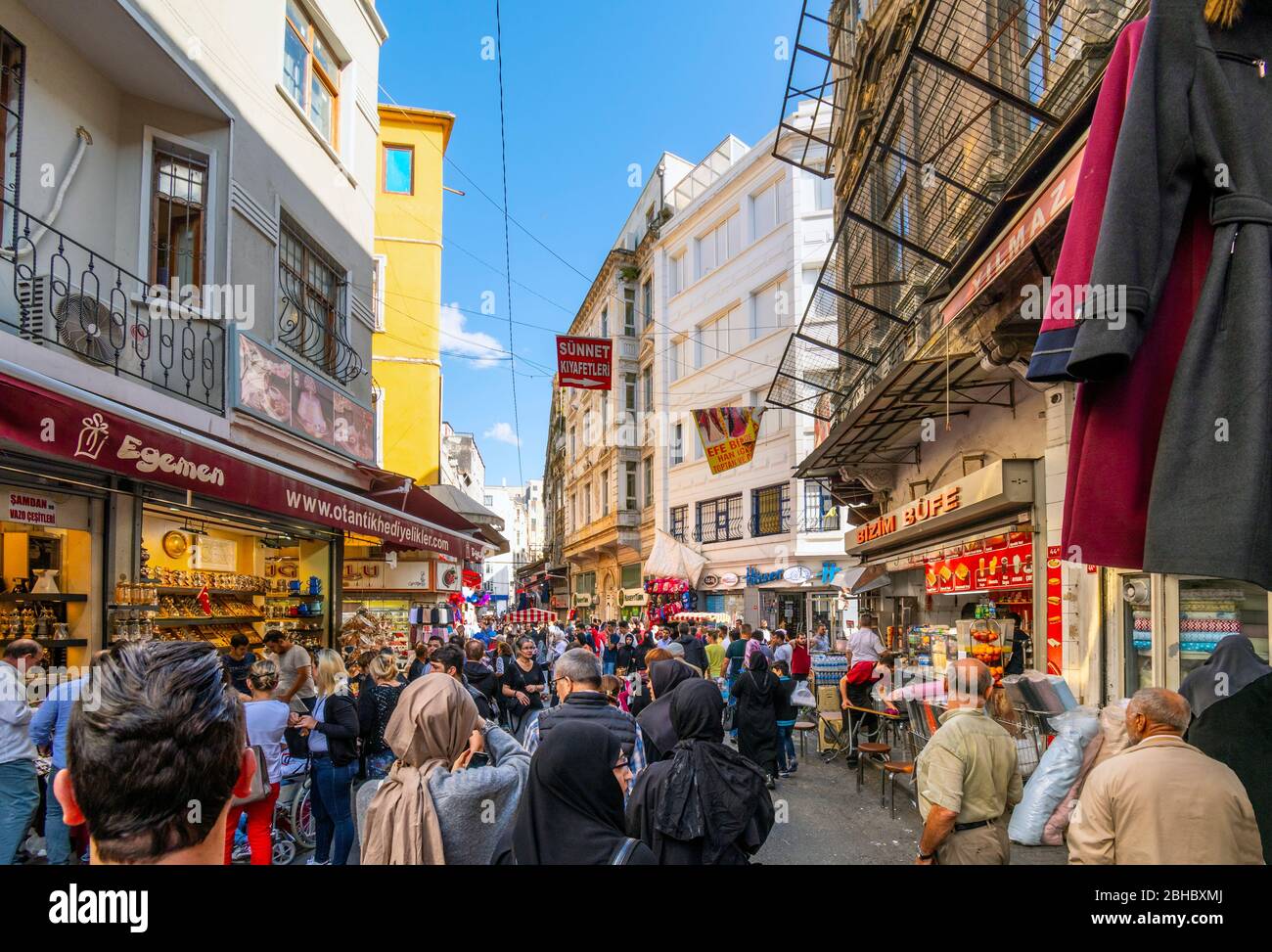 Local Turks pack the streets lined with shops and cafes near the Eminonu Bazaar and market in the Sultanahmet district of Istanbul. Stock Photo