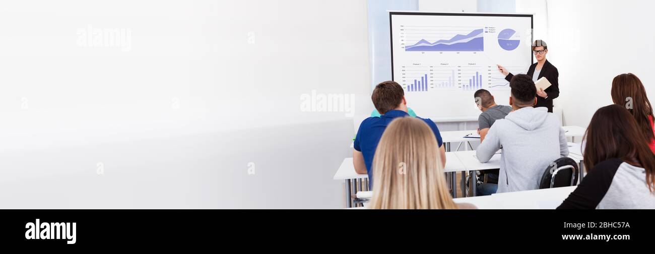 Teacher Doing Presentation To Students In Classroom Using Projector