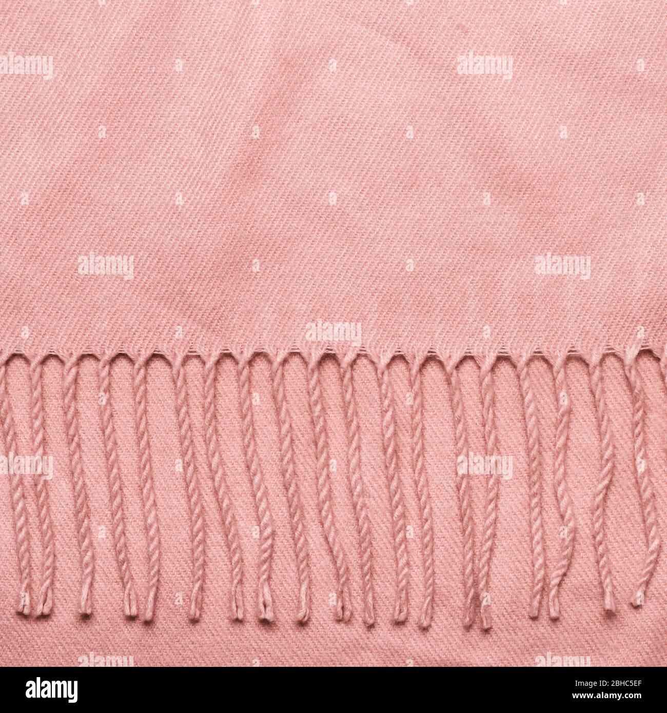 Cozy soft fabric background with copy space. Pink plaid with tassels. Stock Photo