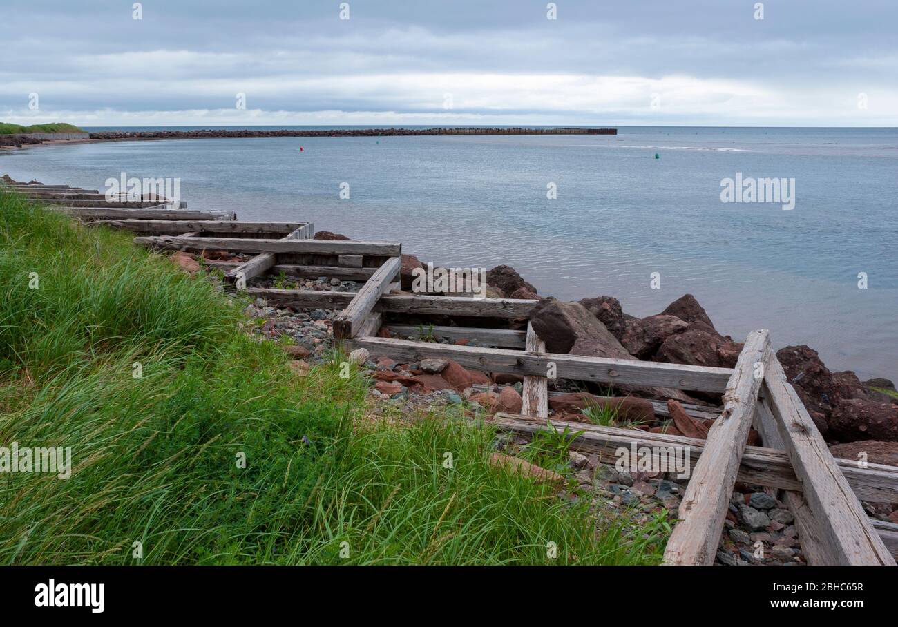 Breakwater in North Rustico Harbor, PEI, CA. Cribwork and riprap along the shore, for coastline protection from heavy seas in the Gulf of St. Lawrence Stock Photo