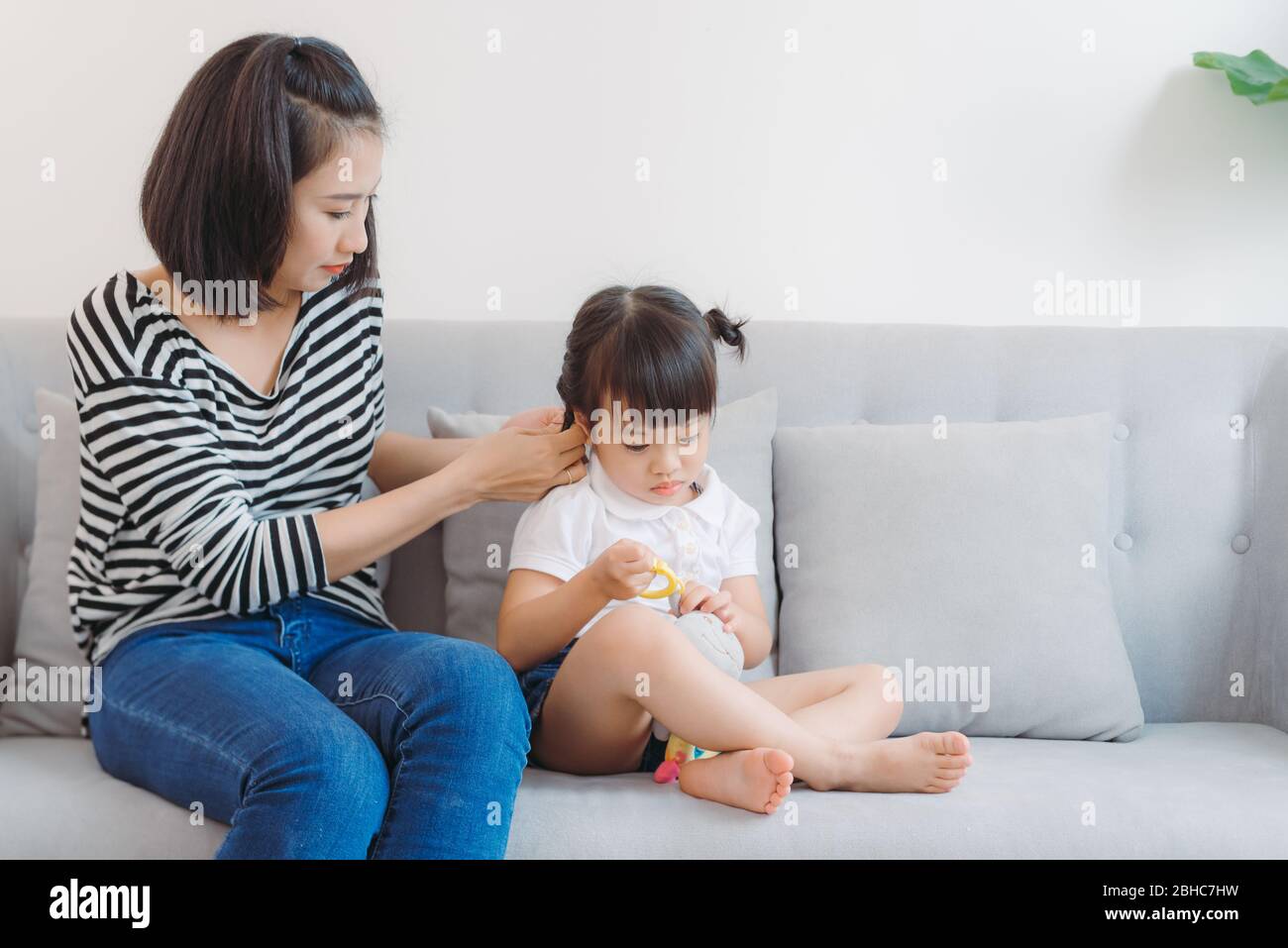 Mother combing daughter, care about hairstyle. Stock Photo