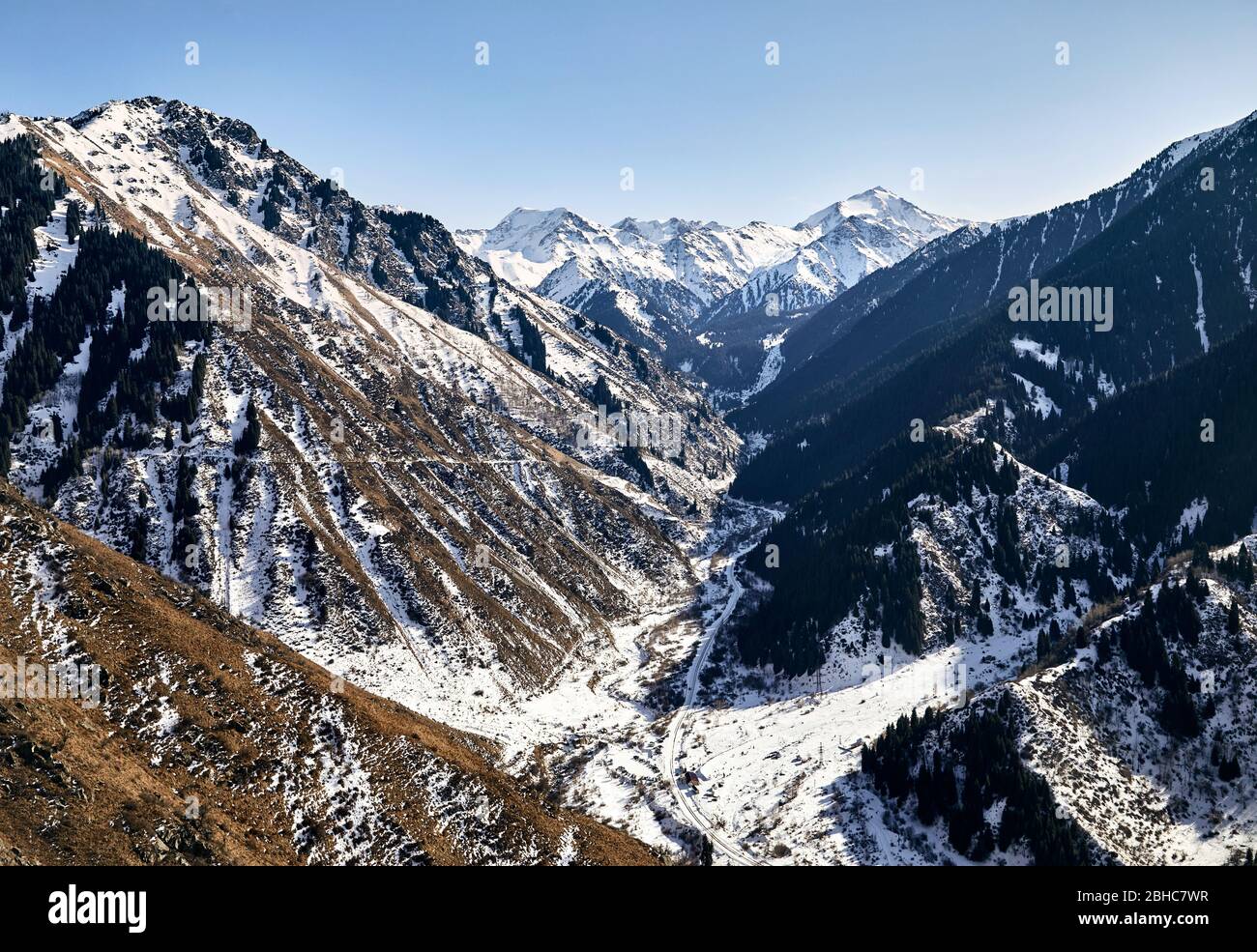 Mountain valley with snow and high peaks against blue sky in Kazakhstan Stock Photo