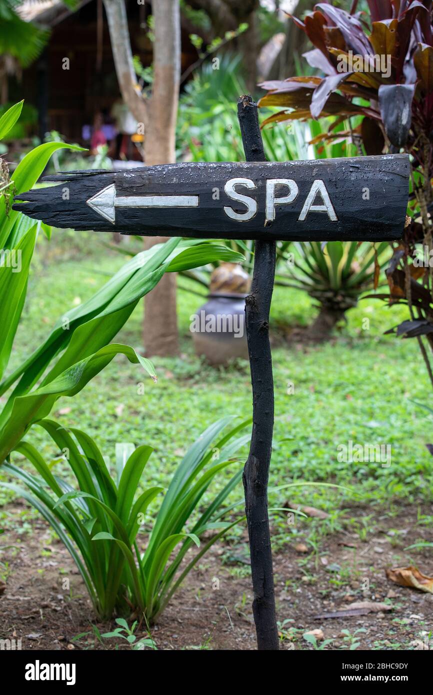 Signboard sign on wooden post with spa inscription. Directions to reach ...