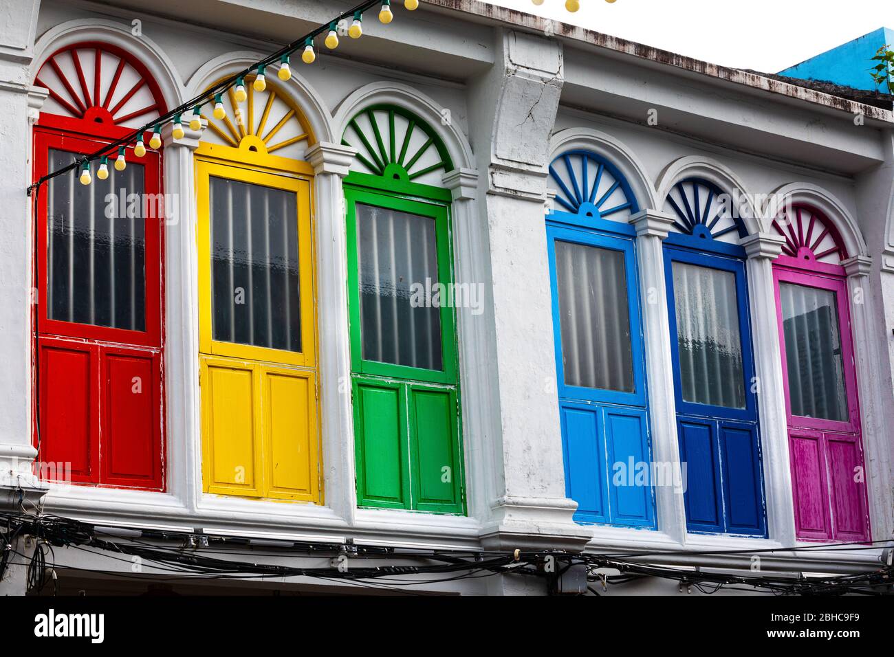 Six colored doors or windows outside on the facade of an ancient house