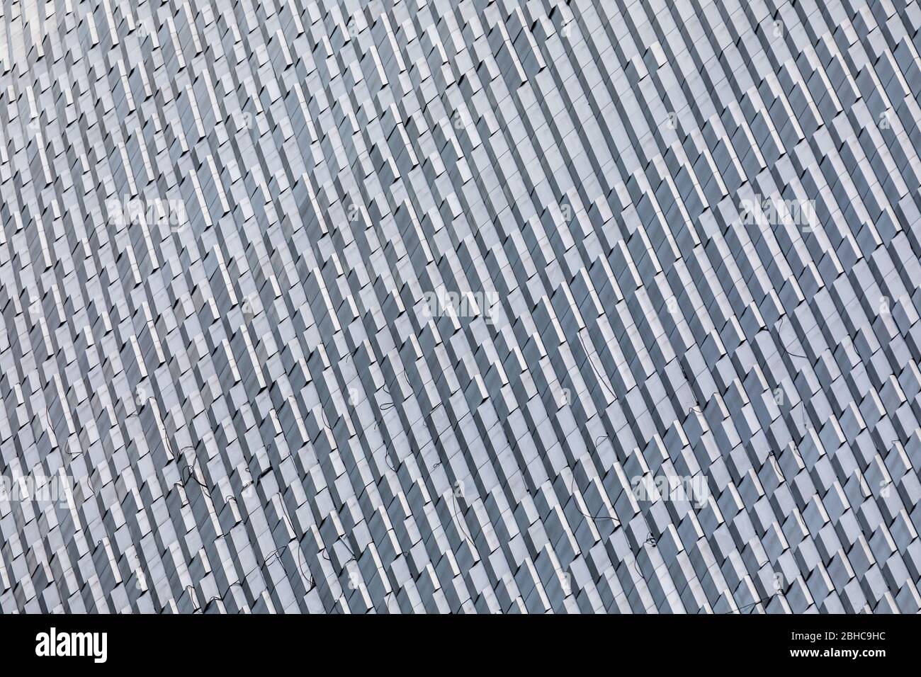 Skyscraper wall abstract background with repeated rectangular cells. Metal gray color with repetitive texture. Stock Photo