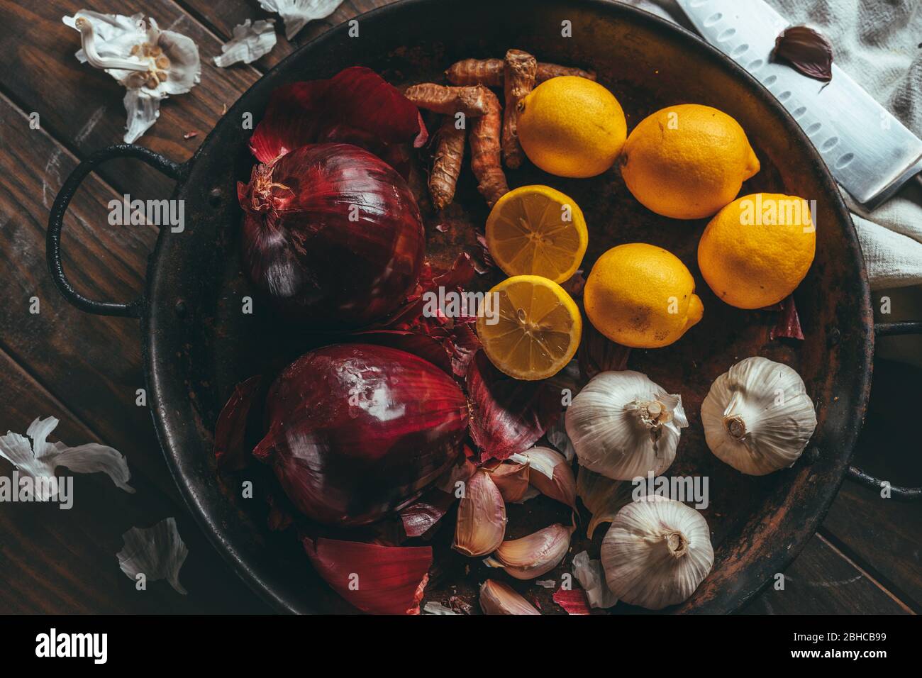 Paella with onion, turmeric, garlic and lemon on a wooden table in a rustic tone Stock Photo