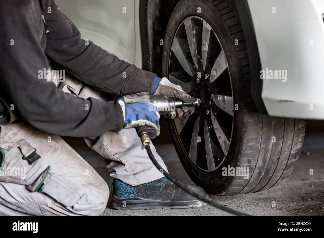 Car, auto mechanic changing tires, wheels on the car by pneumatic