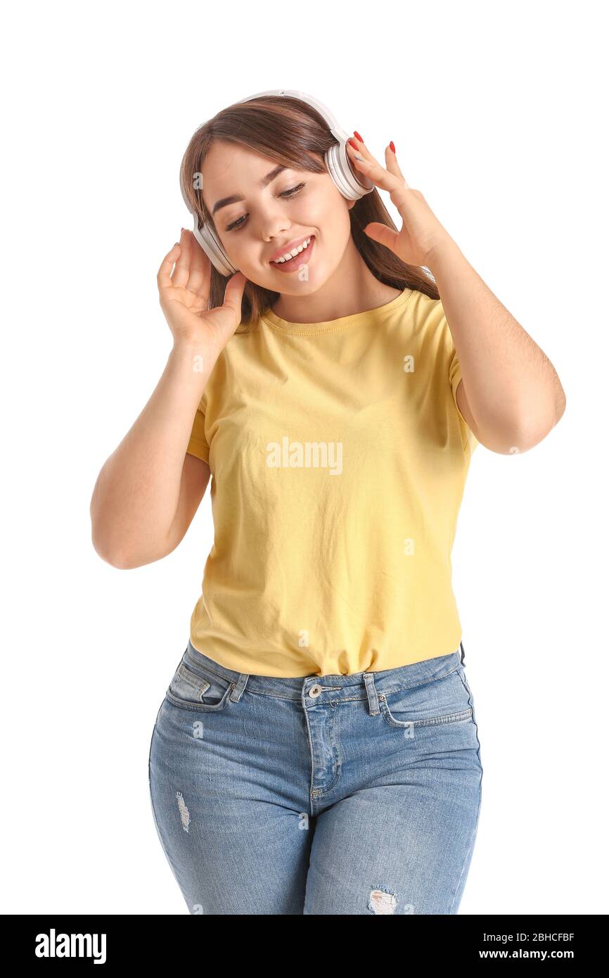 Portrait of beautiful young woman listening to music on white ...