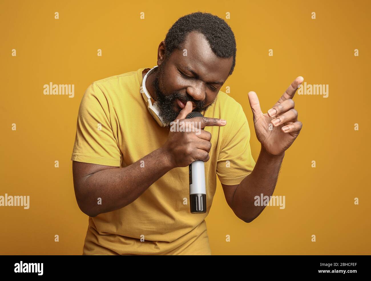 Male African-American singer on color background Stock Photo