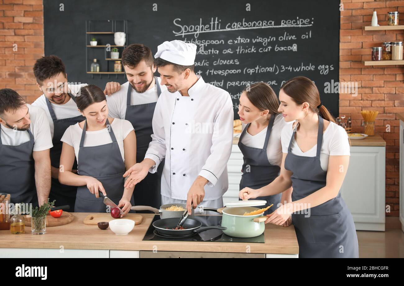 Male chef and group of young people during cooking classes Stock Photo ...
