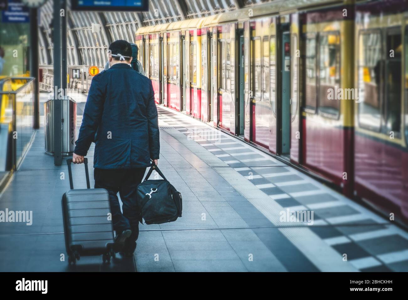 Person with luggage from behind at main train station (Hauptbahnf) in Berlin Stock Photo