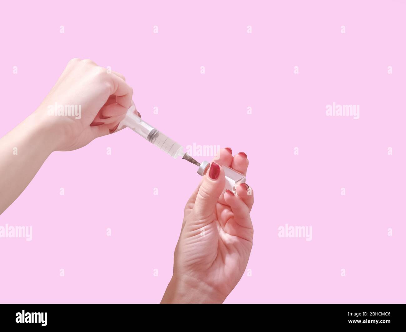 A hand with red nails holds a syringe. Girl holds a syringe for pointed.  Medicine. Pink background, place for text Stock Photo - Alamy