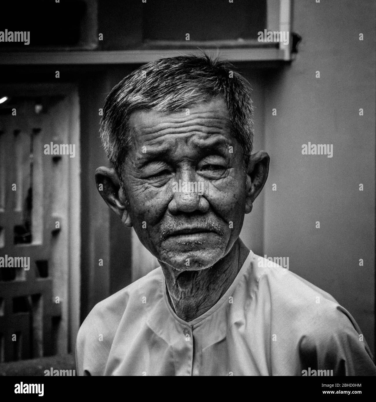 Black and white portrait of  unhappy wrinkled old Vietnamese man looking at camera, Sa Bec,Vietnam, Asia Stock Photo