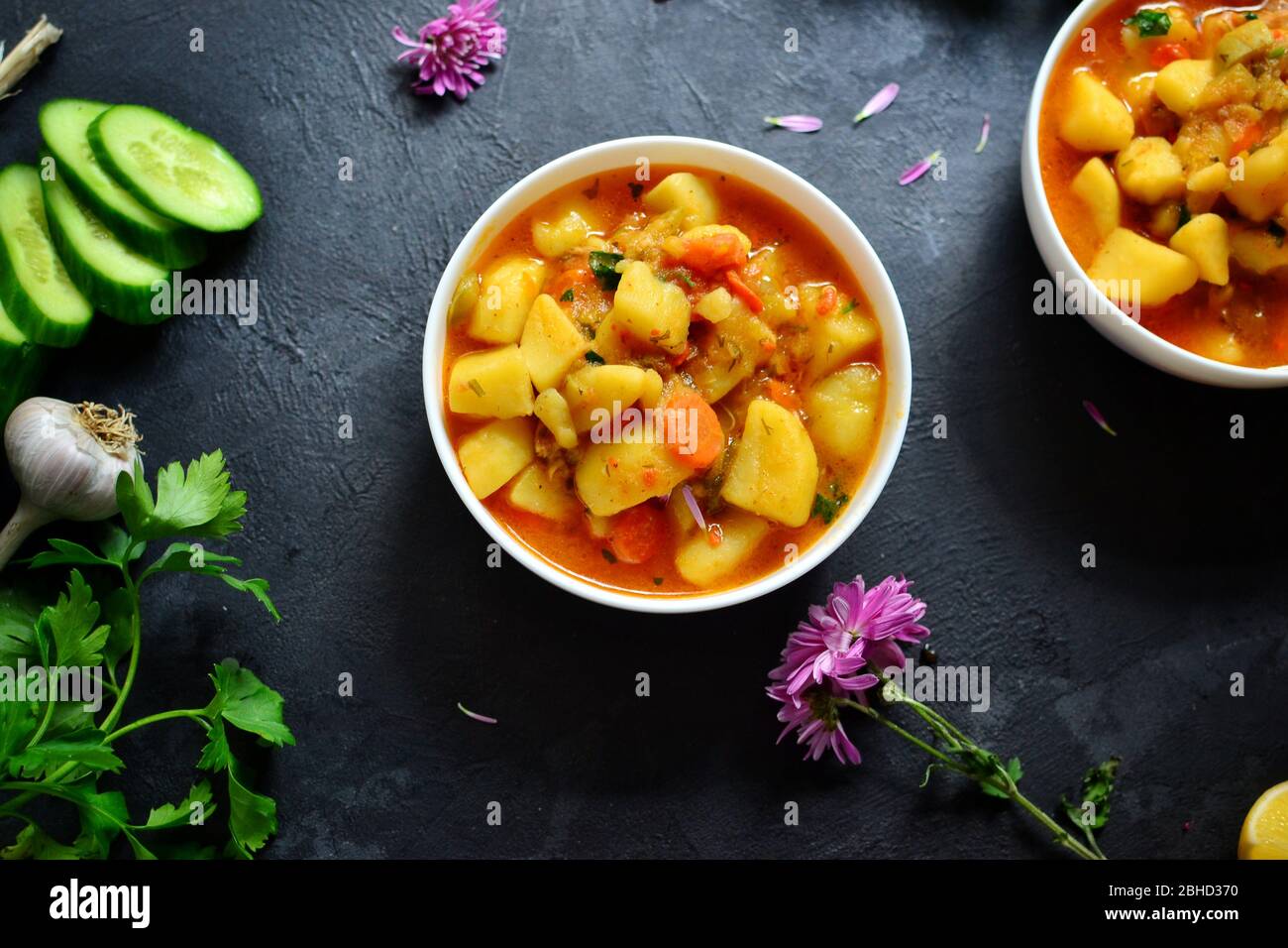 Vegetable stew in a white bowl. Photo food. Stew with potatoes and carrots on a dark concrete background. Healthy vegetarian food. Top view Stock Photo