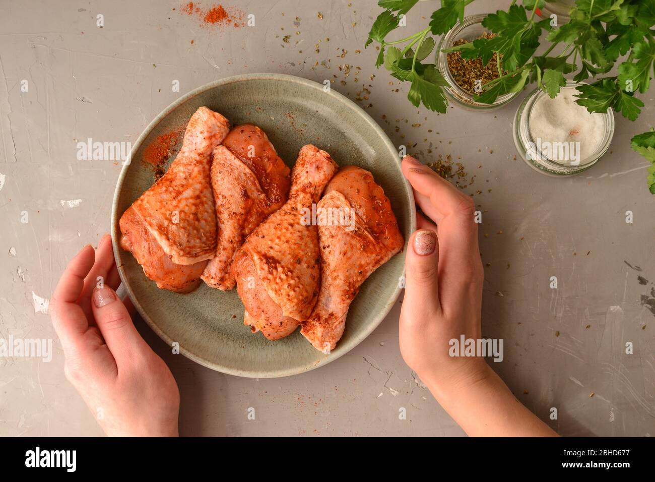 Raw chicken in a plate. Marinated meat, with oregano, herbs and paprika