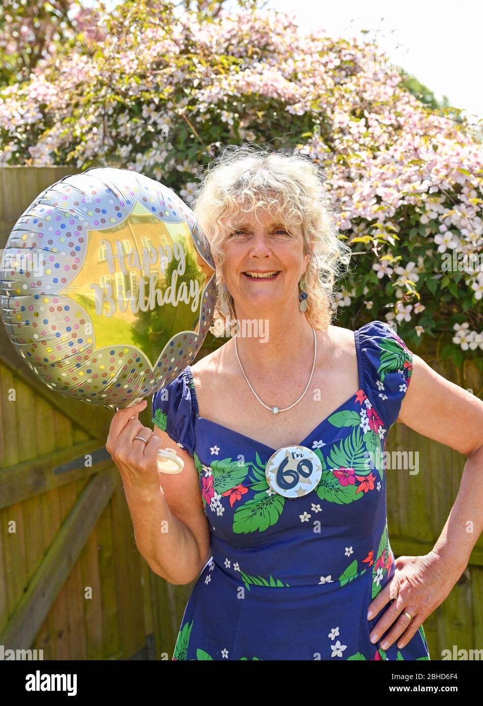 Woman celebrating her 60th birthday at home during UK lockdown in the coronavirus COVID-19 pandemic Stock Photo