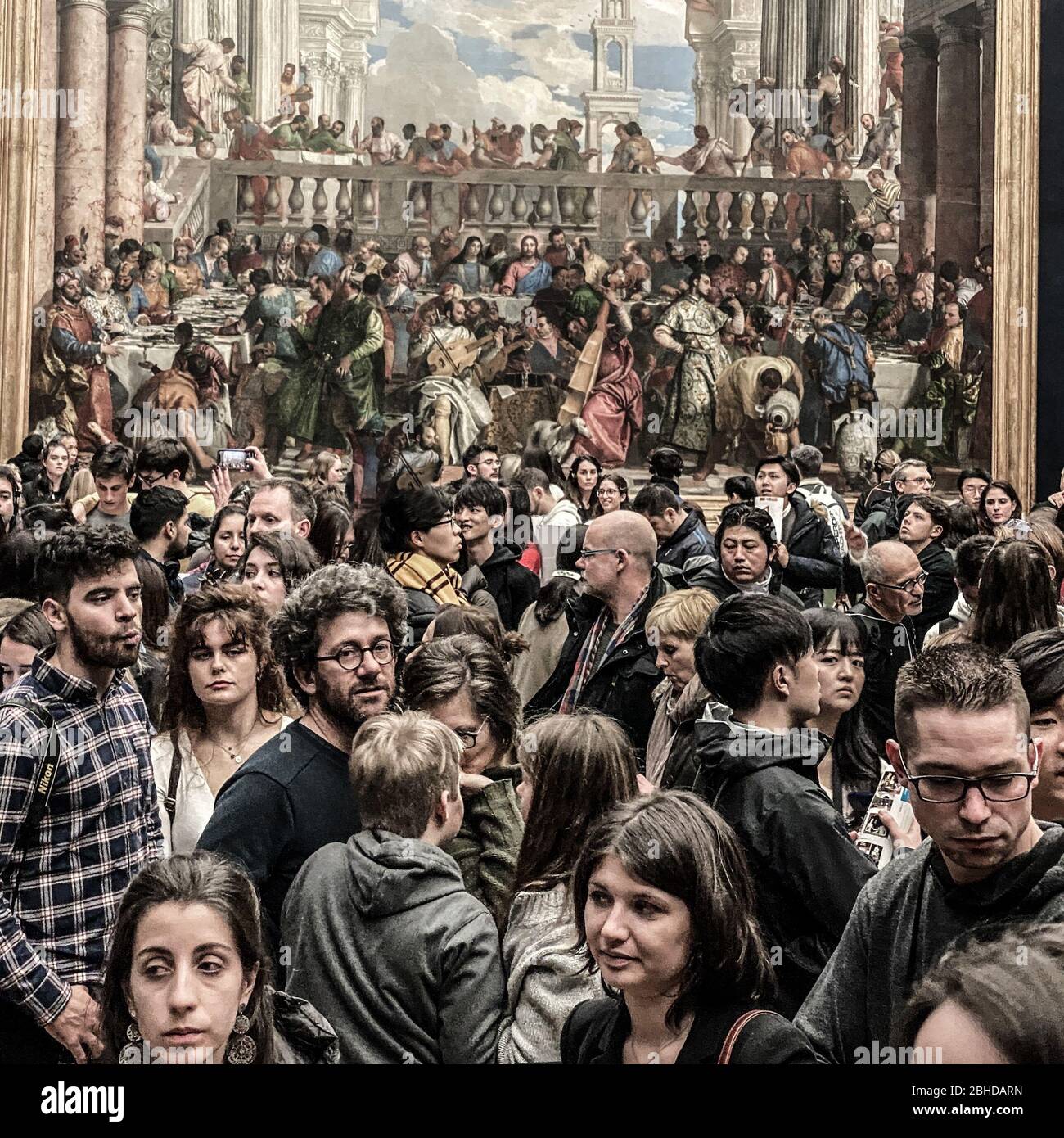 Pais, France, Febuary 21, 2020,  Dense crowd of tourists in the Louvre museum, in front of 'Les noces de Cana' . Large number of unidentified people Stock Photo