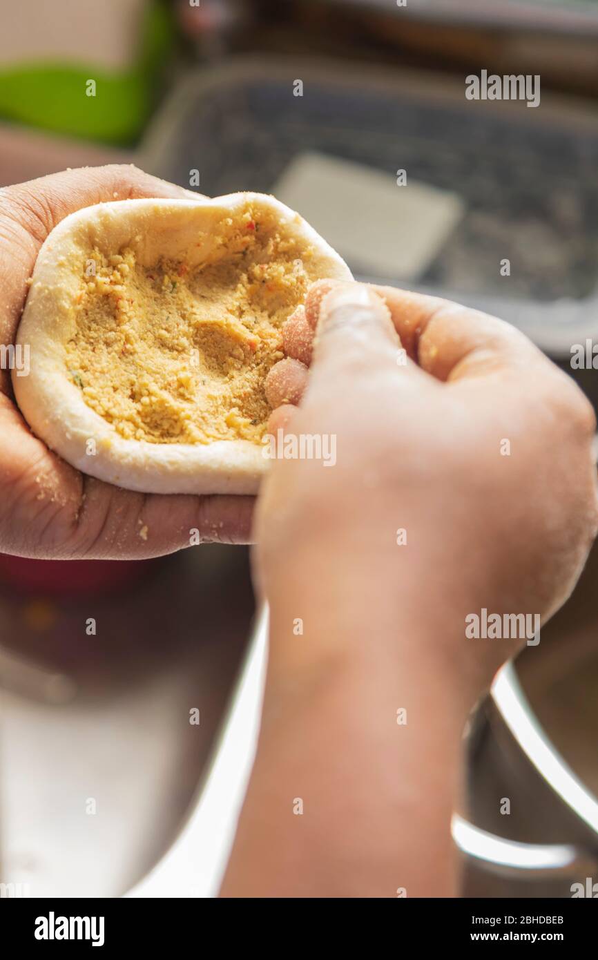 shaping dough cup with yellow split peas and coriander powder to make dhal flatbread Stock Photo