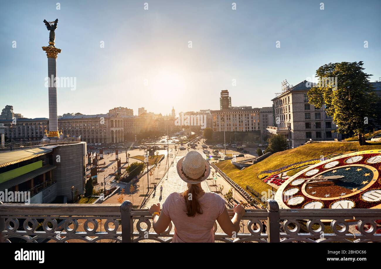 Woman tourist is looking at famous Independence Square Maidan Nezalezhnosti at sunset in Kiev, Ukraine Stock Photo