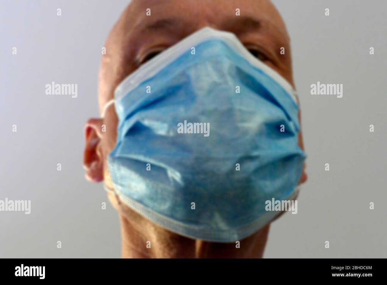 Mann mit blauer Atemschutzmaske; unscharf; Gesicht; Portrait; Deutschland; Europa Stock Photo