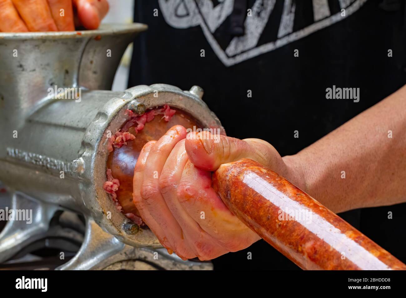 Mincing pork into casing  to make dried Italian Sausages Stock Photo
