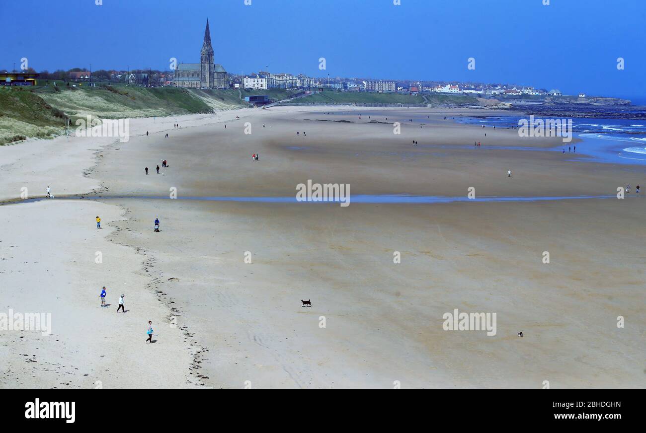 People practicing social distancing at Tynemouth beach as the UK continues in lockdown to help curb the spread of the coronavirus. Stock Photo