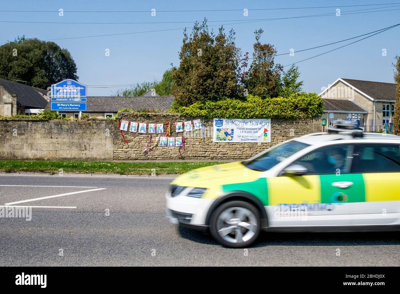 Chippenham, Wiltshire UK, 25th April, 2020. A Medvivo Mobile Care Response car is pictured as it drives past a 'thank you NHS' sign that has been hung on a school wall opposite Chippenham Community Hospital. Medvivo provide GP out of hours services to patients who are registered with a GP within the Bath and North East Somerset, Swindon and Wiltshire clinicial commissioning areas. Credit: Lynchpics/Alamy Live News Stock Photo