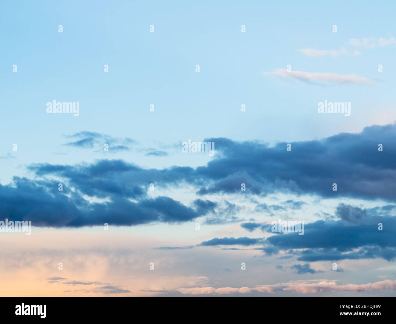 dark cumuli clouds in blue sky at spring sunset Stock Photo