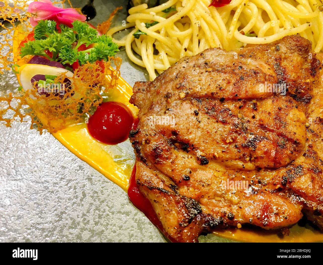 Photo of Pork steak and spaghetti and gravy on black dish ready to eat ...