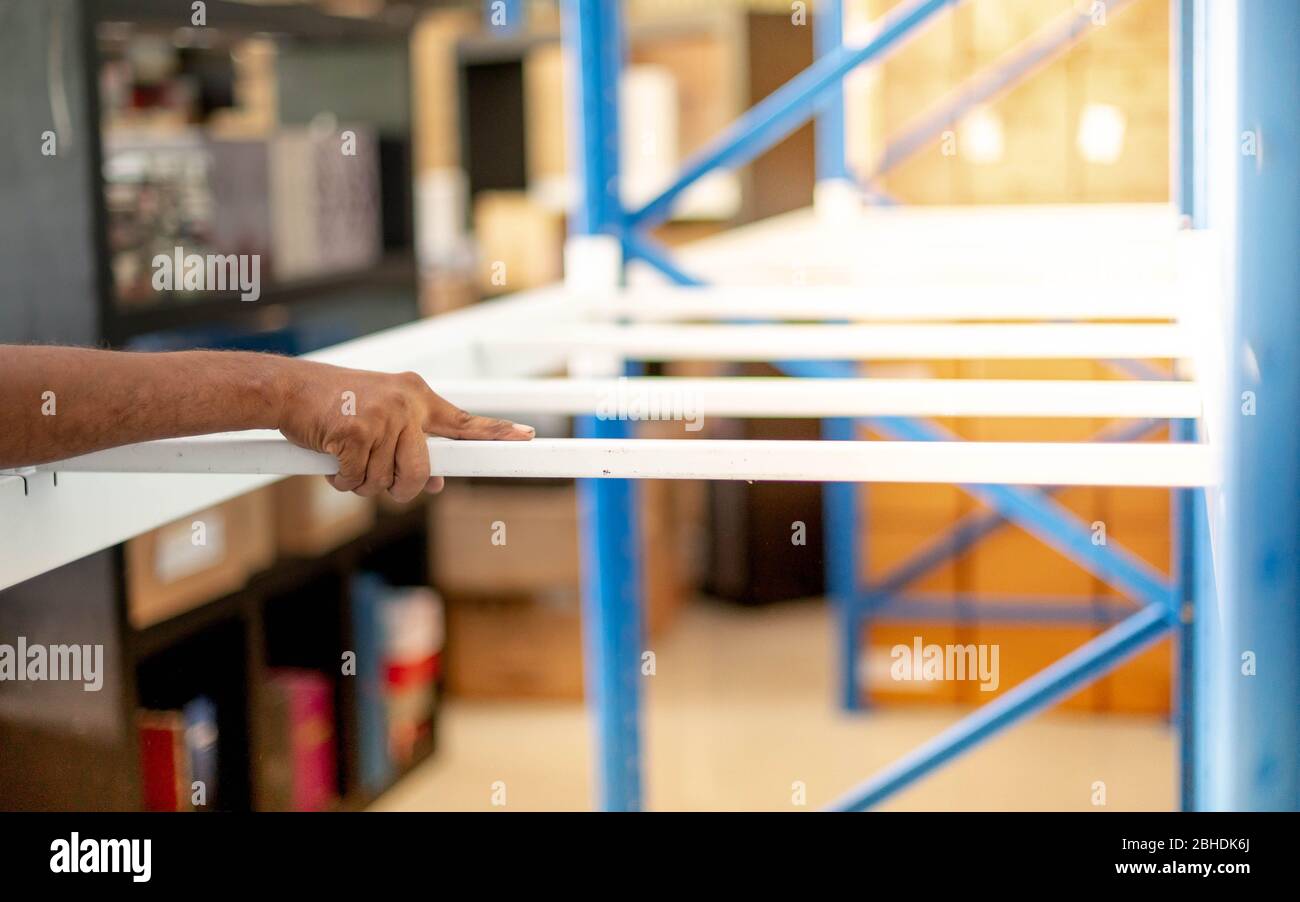 Male hand preparing to assembling the metal rack in in warehouse or ...