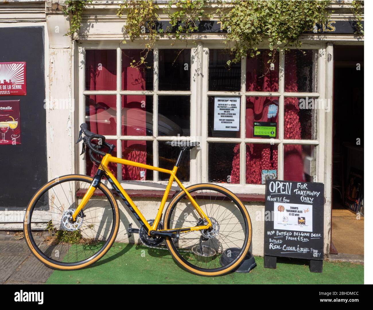 Bicycle parked outside the Portcullis a local pub in Clifton village Bristol selling takeaway beers during the 2020 Coronavirus pandemic lockdown Stock Photo