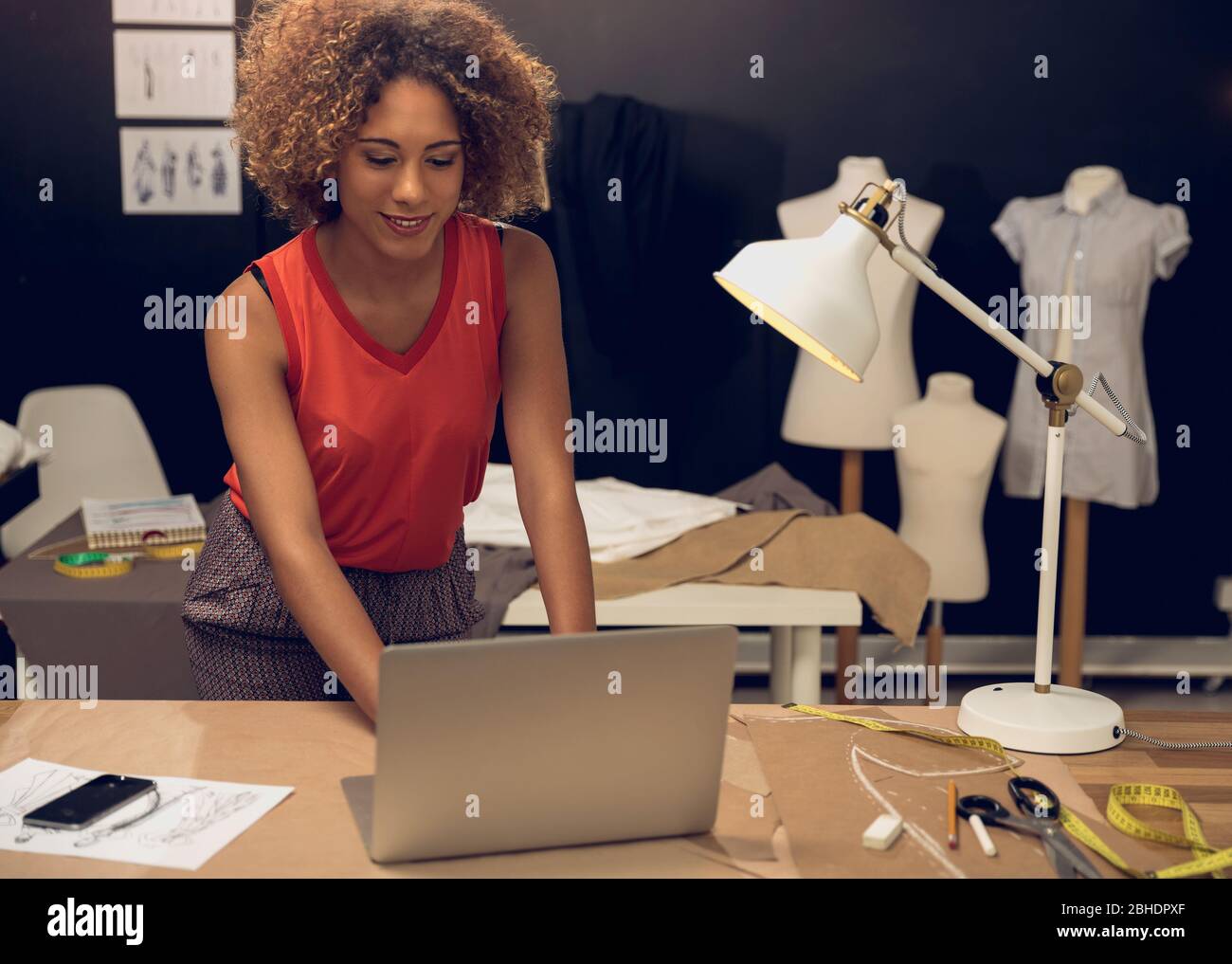 A young fashion designer working on her atelier Stock Photo - Alamy