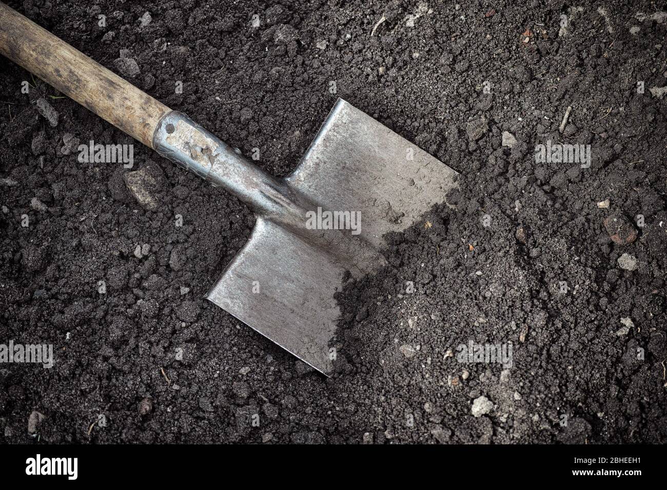 Old shovel in soil. Low key. Close up. Stock Photo