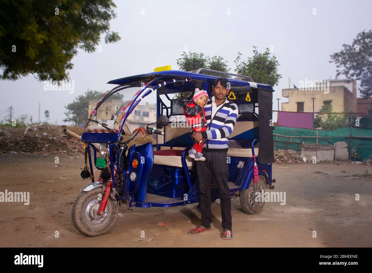 Indian E rickshaw driver with his child, India Stock Photo
