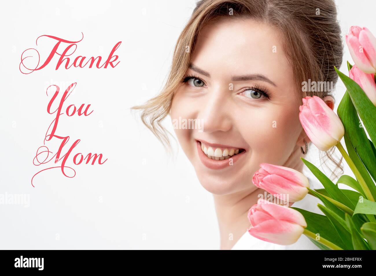 Smiling young woman with pink tulips, sign text Thank You Mom on ...