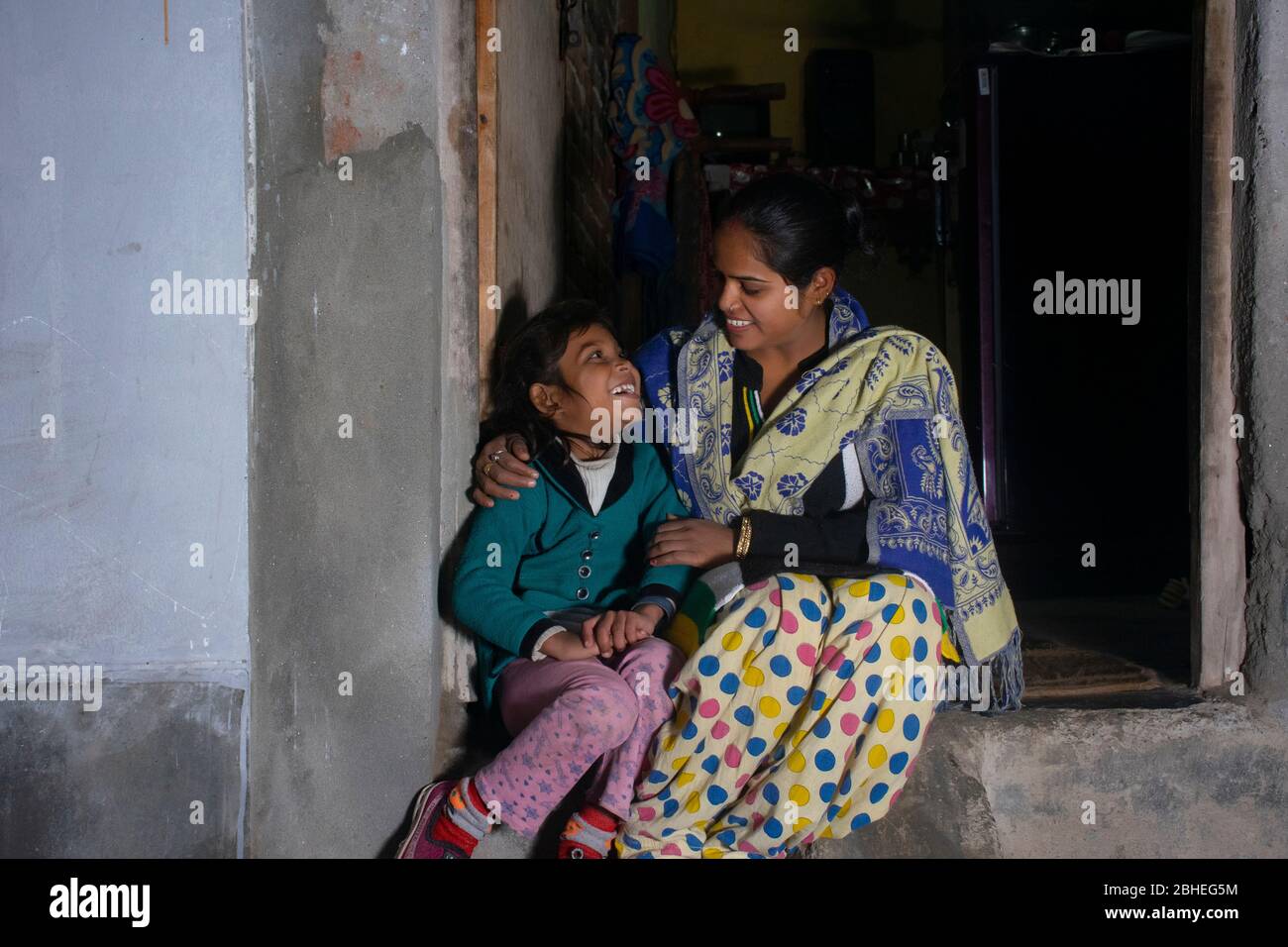 indian rural mother and daughter sitting at door of the house Stock Photo