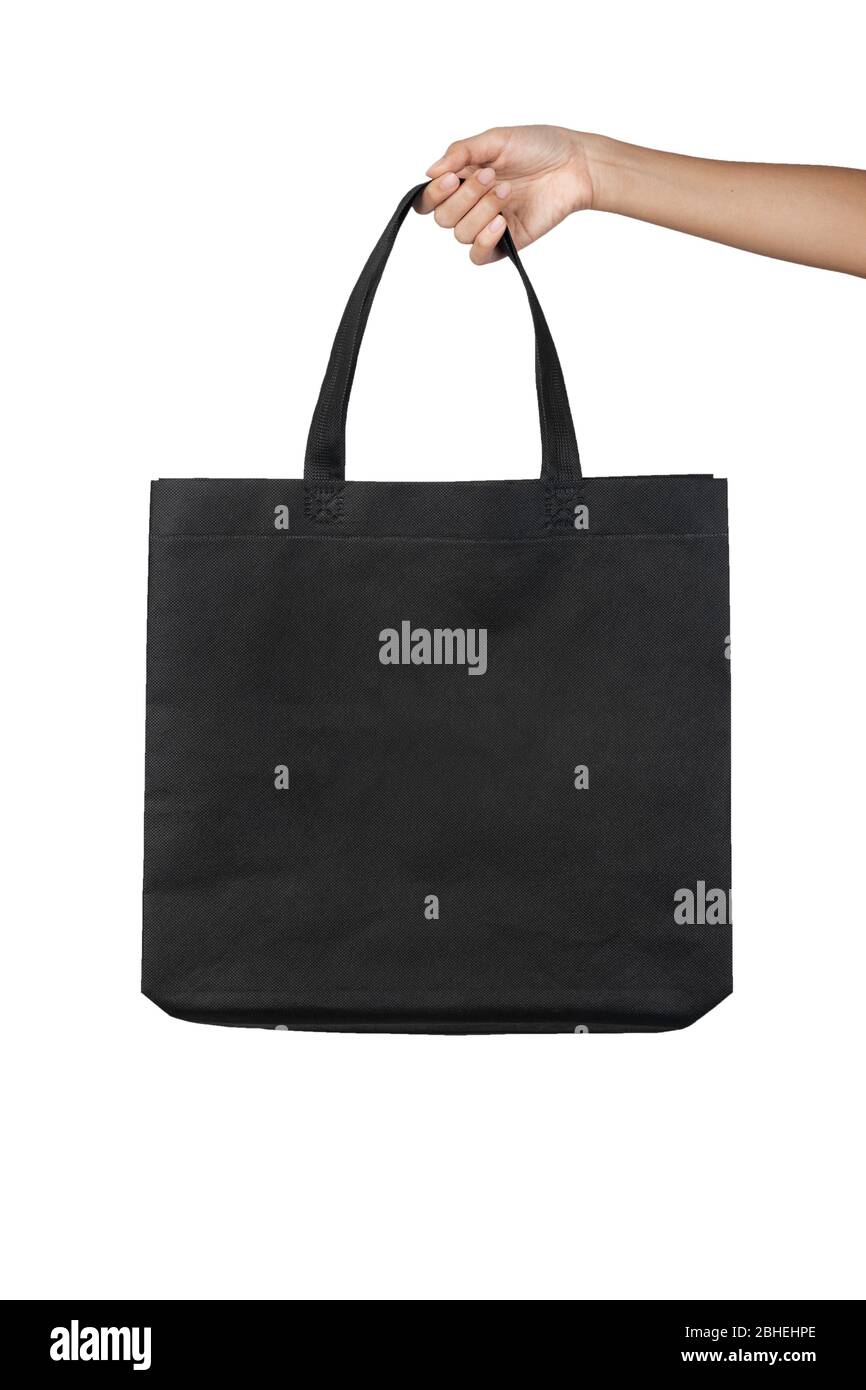 Hand holding blank black fabric canvas bag isolated on white background with clipping path, eco concept. Stock Photo