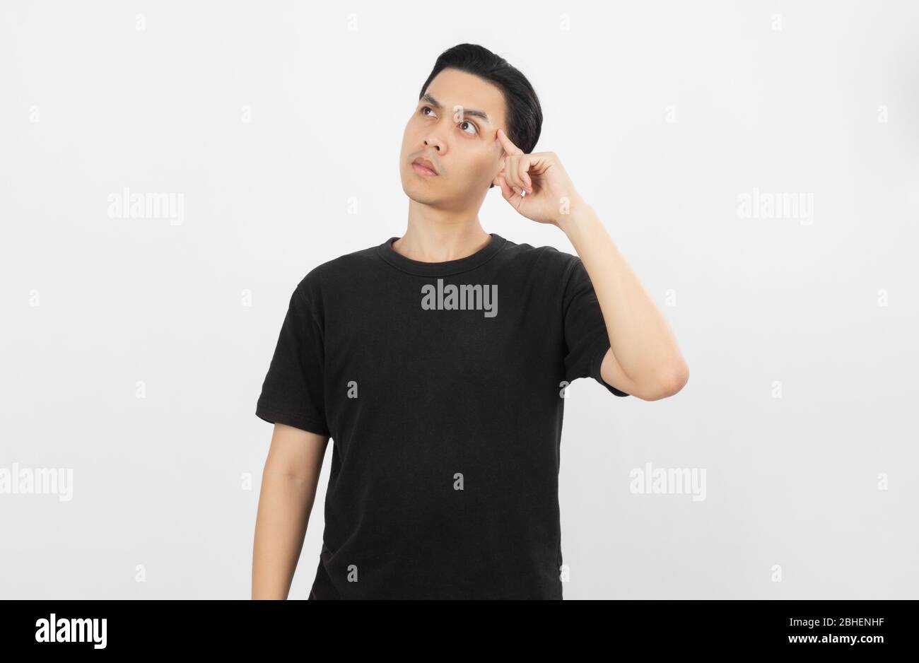 Young asian man with black shirt having doubts and with confuse face expression while scratching head on isolated on white background. Stock Photo