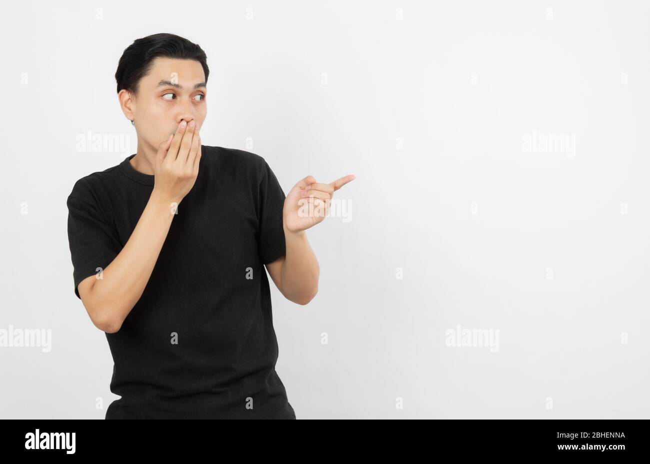 Young asian man with black shirt pointing to the side with a finger to ...