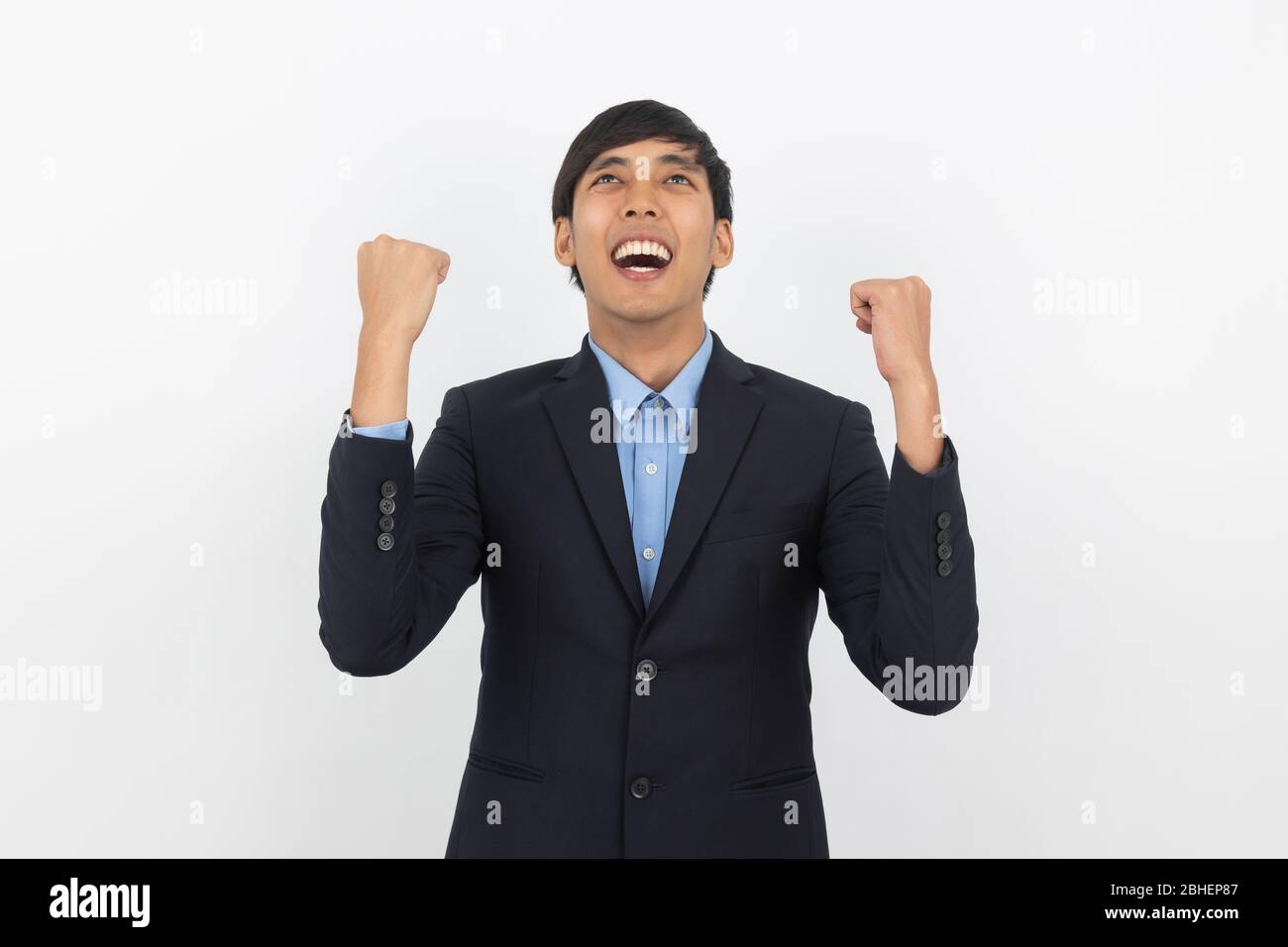 Excited young business Asian man raising his fists with happy delighted ...