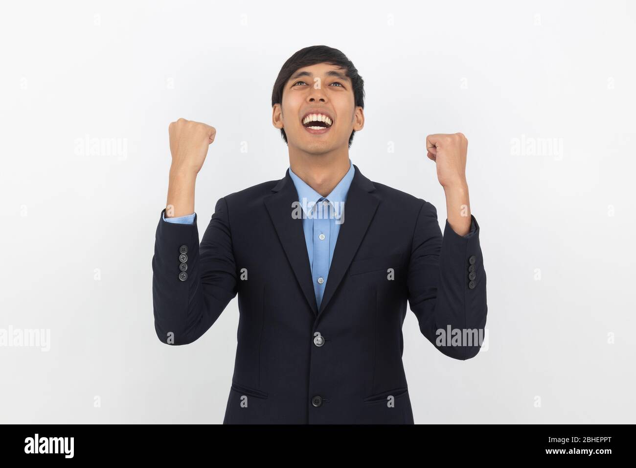 Excited young business Asian man raising his fists with happy delighted ...