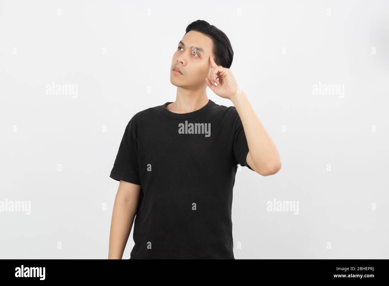 Young asian man with black shirt having doubts and with confuse face expression while scratching head on isolated on white background. Stock Photo